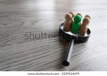 Wooden dolls on top of magnifying glass. Human resources, target market and audience, focus group concept Royalty-Free Stock Photo #2339524479