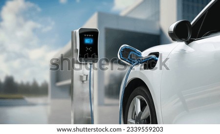 Innovative electric car connected to charging station with future architecture building background. Technological advancement rechargeable EV car using alternative clean and sustainable energy. Peruse Royalty-Free Stock Photo #2339559203