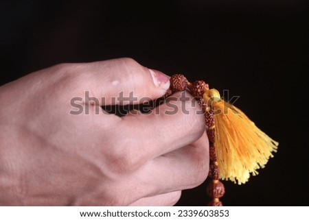 Buddhist prayer beads in a woman's hand on a dark background Royalty-Free Stock Photo #2339603853