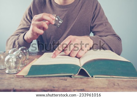 A young man is reading and studying cupping therapy Royalty-Free Stock Photo #233961016