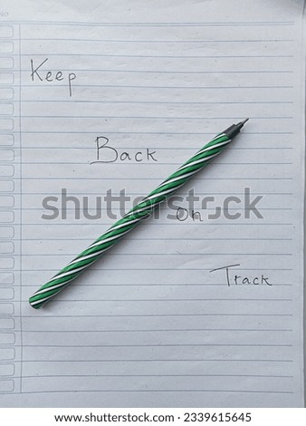 A picture of paper and pen written "keep back on track".