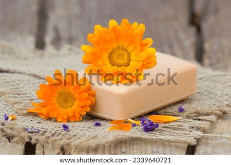 Natural handmade soap with calendula (pot marigold) on rustic wooden background