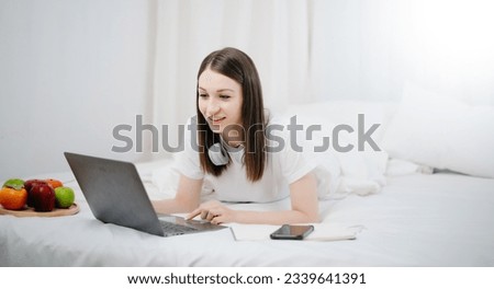 Beautiful woman resting and watching movie in bed at bedroom in morning Lifestyle at home concept.
