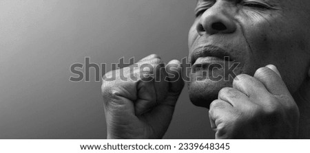 man praying to god with hands together Caribbean man praying worshiping God stock image stock photo