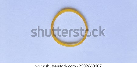 A single yellow elastic rubber band isolated with white background.