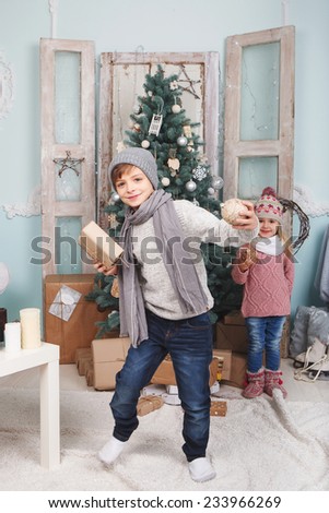 Boy and little girl arount the Christmas tree