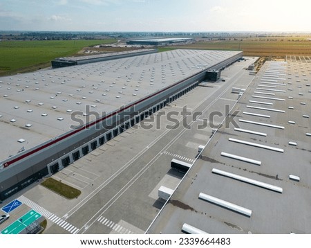 aerial drone view of  warehouse building with bays and trucks
