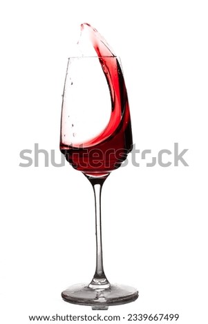 a glass with a dynamic movement of the wine inside  Royalty-Free Stock Photo #2339667499