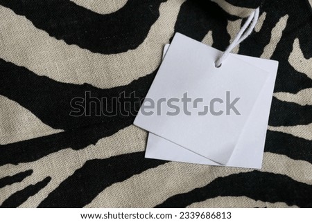 Close up of price tag of clothing item. Blank label tag mockup on clothes. Fashion industry and retail concept. 