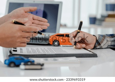 Up close shows the calculator for the cost of the car and the rental interest that must be paid. The car dealer or sales manager offers to sell the car and explains the terms of the car contract and i Royalty-Free Stock Photo #2339693319
