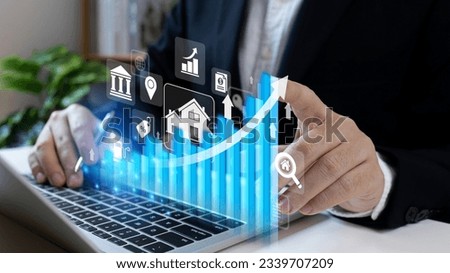 Real estate revenue graph growth. Businessman hand touching on a  graph and growing arrow.Increase asset and profit with house icon, analyzing investment diagram, achievement in business. Royalty-Free Stock Photo #2339707209