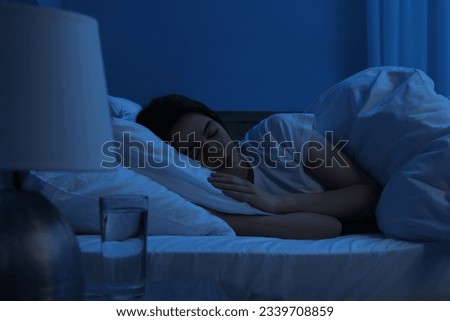 Beautiful young woman sleeping in bed at night Royalty-Free Stock Photo #2339708859