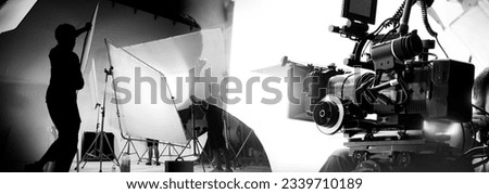 Silhouette of video production behind the scenes or B roll or making of TV commercial movie that film crew team lightman and cameraman working together with director in big studio with pro equipments Royalty-Free Stock Photo #2339710189