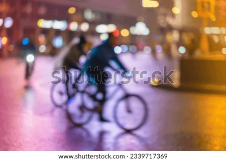 Abstract unrecognizable people, riding bikes, night city, illumination bokeh, motion blur. Healthy lifestyle, night city activity concept Royalty-Free Stock Photo #2339717369