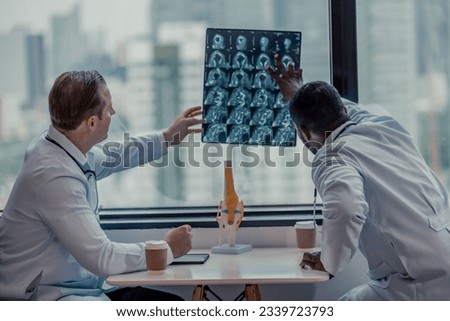 Physicians spend break time analyzing medical images, including MRI films of patient conditions, in order to develop treatment plans and future medical procedures and refer patients to specialists. Royalty-Free Stock Photo #2339723793