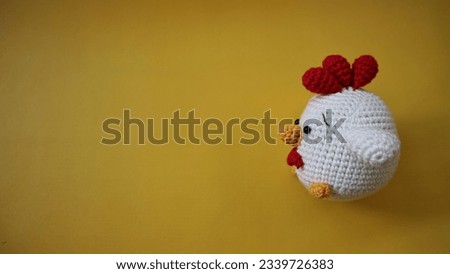 Chicken, Amigurumi, Toy Animal isolated on yellow background. Made of cotton yarn with single crochet technique. Art and craft Concept photography.