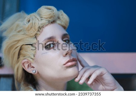Italian girl cosplay Giorno Giovanna from the anime jojo. Blond woman with blue eyes. Close up to the sea and greenery.