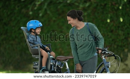 Mother and child together child sitting bicycle seat laughing with mom bonding moment Royalty-Free Stock Photo #2339747019