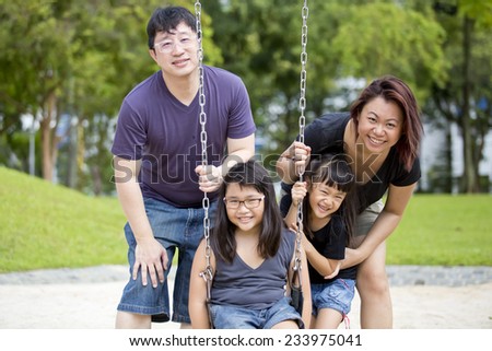 Young Asian family playing swing bonding in park