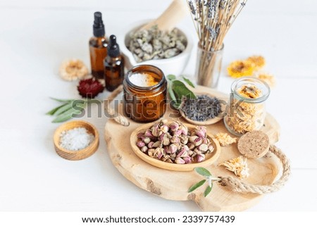 Botanical blends, herbs, essencial oils for naturopathy. Natural remedy, herbal medicine, blends for bath and tea on white wooden table background Royalty-Free Stock Photo #2339757439