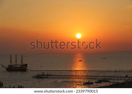 Beautiful sunset on the sea in Side in Turkey with a pirate boat in the sea