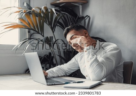 Stressed tired man in pain having strong terrible headache attack after computer laptop work, fatigued exhausted guy suffering from chronic migraine massaging temples to relieve head ache tension Royalty-Free Stock Photo #2339801783