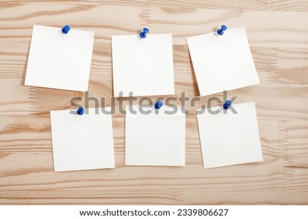 Six white paper notes mockup pinned to wooden bulletin board. sticky notes on bulletin board. Three sticker with push pins on wooden background Royalty-Free Stock Photo #2339806627