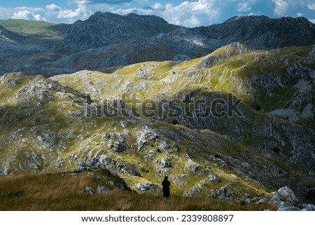A lonely woman in the middle of a mountain wilderness