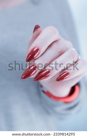 Female hand with long nails and a bright red manicure