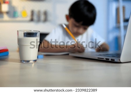Milk Refreshments on the Table for Children Student Drink After Learning at Home, Early Education, Studying, and Healthy Habits at Home. Royalty-Free Stock Photo #2339822389