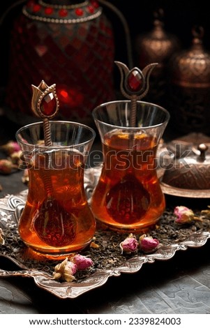 Traditional Turkish tea with dried tea leaves on copper tray, selective focus