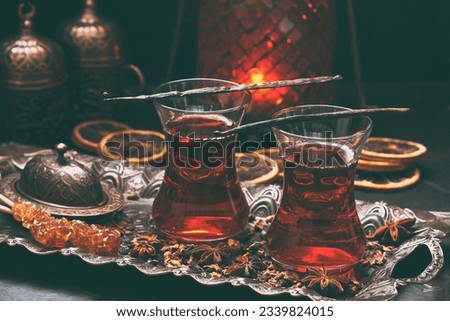 Cup of freshly brewed red karkade tea, eastern  tea ceremony,  on dark concrete background