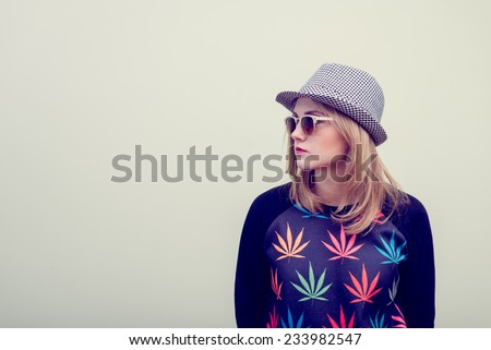 Studio portrait of teenage hipster girl wearing trendy eyeglasses and hat over olive copy space background Royalty-Free Stock Photo #233982547