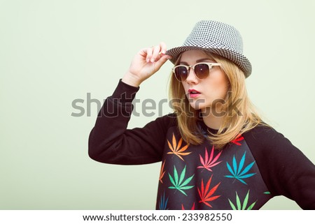 Studio portrait of teenage hipster girl wearing trendy eyeglasses and hat over olive copy space background Royalty-Free Stock Photo #233982550