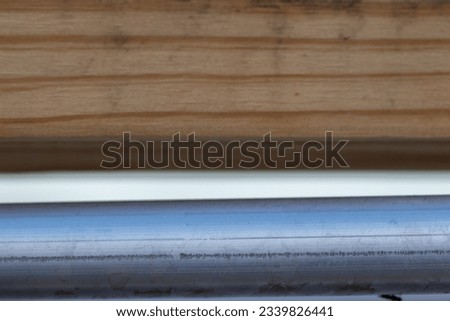 close up of metal pipe tube and wood background