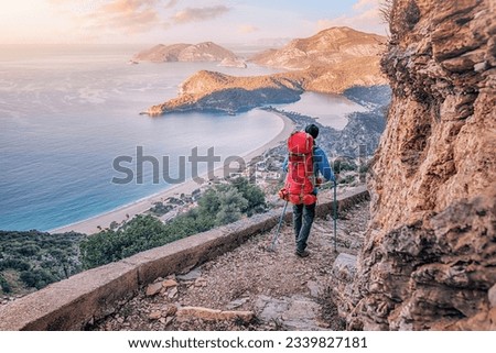Happy hiker man with trekking backpack at a viewpoint of Lycian Way trail in Oludeniz, Fethiye. Travel and adventure in Turkey Royalty-Free Stock Photo #2339827181