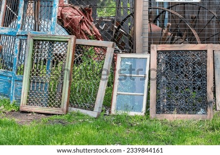 salvage windows and doors with decorative metal work , are for sale at a Michigan USA salvage yard Royalty-Free Stock Photo #2339844161