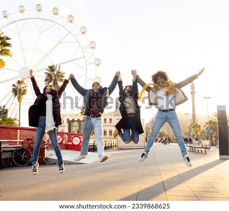 Group of multiethnic young people in winter clothes having fun jump together in a city