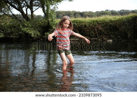 Young boy wading in a stream  Royalty-Free Stock Photo #2339873095