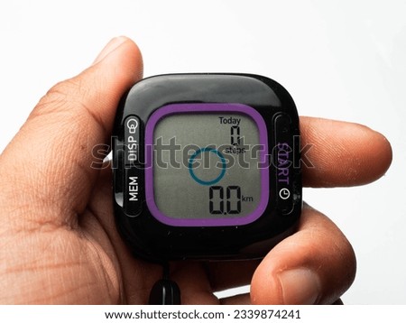 Picture of a black digital pedometer, a device for counting steps