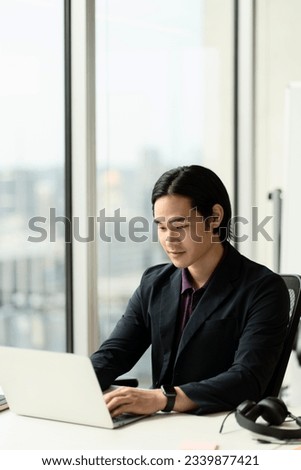 Handsome asian student studying using laptop computer, online education concept. Portrait of successful programmer sitting at workplace 
