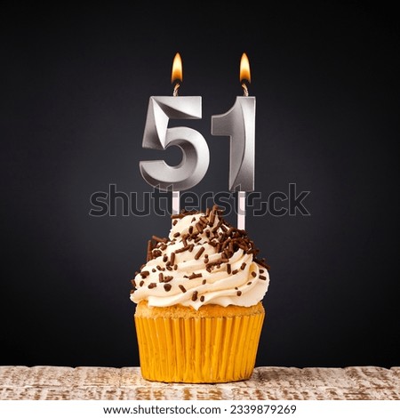 Birthday candle number 51 - Anniversary cupcake on black background Royalty-Free Stock Photo #2339879269