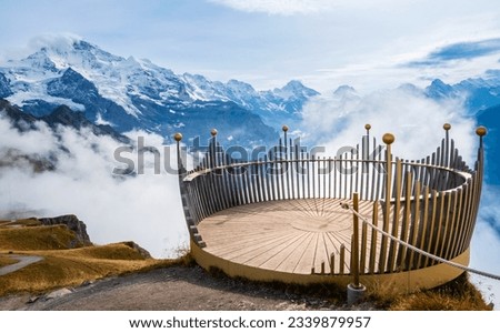 Viewpoint on summit of Mannlichen mountain near Lauterbrunnen and Grindelwald, Switzerland. Snowcovered peaks of Swiss Alps in low clouds. Crown on top: concept of success and victory Royalty-Free Stock Photo #2339879957