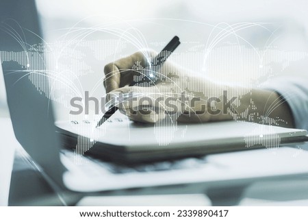 Double exposure of abstract digital world map with connections and hand writing in notebook on background with laptop, research and strategy concept