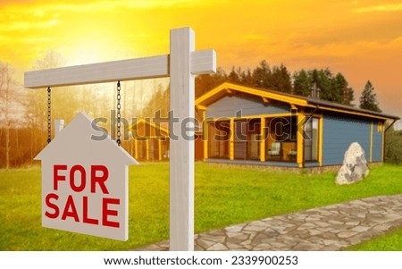 House for sale. Finding buyers real estate. Wooden sign for sale. Cottage with green lawn at sunset. Sale country villa. One-story house is waiting for buyers. Selling house in eco-friendly location