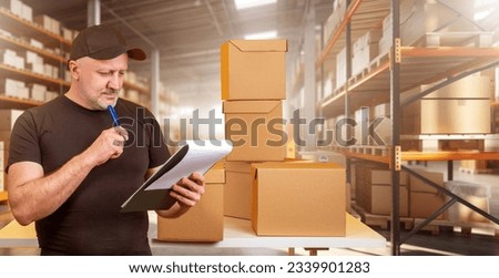 Man is storekeeper. Guy near racks with boxes. Storekeeper is holding clipboard. Industrial storage worker. Man works as storekeeper in factory. Businessman thought. Fulfillment business Royalty-Free Stock Photo #2339901283