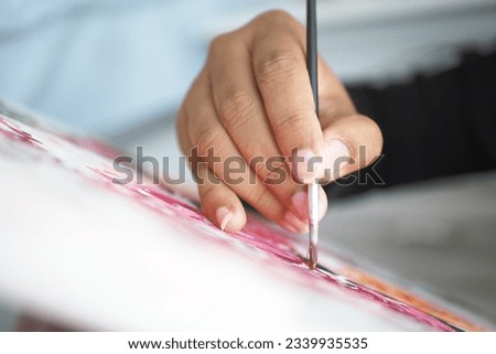 women hand holding brush with paint 