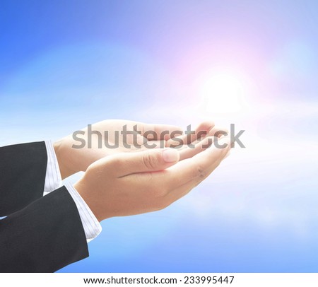 Businessman open empty hands with palms up, over blurred beautiful blue sky background.