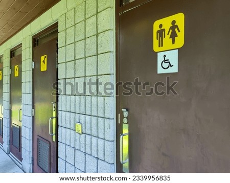 A public restroom in the environmental conservation park, with one specifically designed and designated for use by disabled individuals.