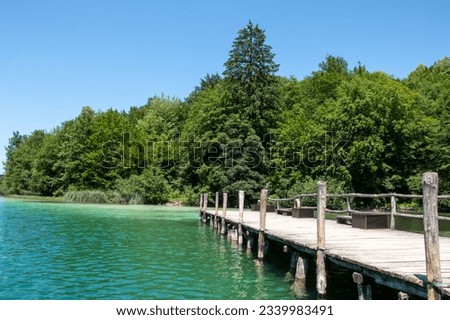 Wooden pier edging into the magnificent turquoise waters of Lake Kozjak in Plitvice Lakes National Park in Croatia Royalty-Free Stock Photo #2339983491